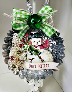 a christmas ornament hanging from a pole with green bows and decorations on it