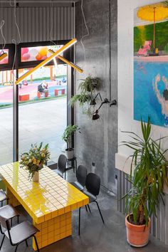 a yellow table and some chairs in a room