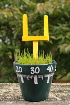 a green and yellow planter sitting on top of a wooden table