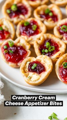 cranberry cream cheese appetizer bites on a white plate with green garnishes