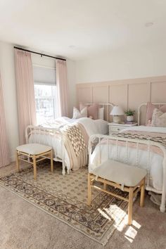 a bedroom with two beds and pink curtains