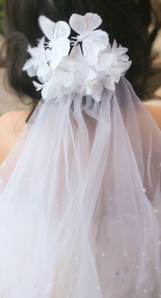 a woman wearing a veil with flowers on it