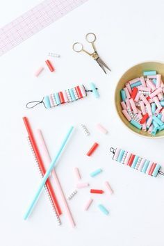 the scissors are laying next to some colored toothbrushes and other crafting supplies