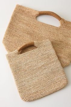 two bags made out of jute and wooden handles on a white surface with a wood handle