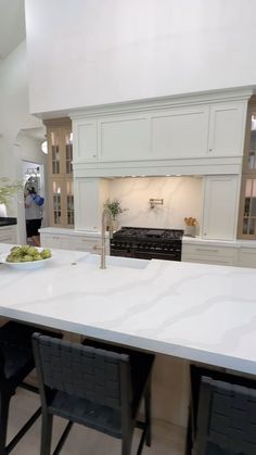 a kitchen with white counter tops and black chairs