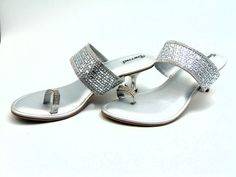 From our newest collection, A gorgeously crafted silver wedge with a toe ring strap set with silver colored crystals and a center strap intricately adorned with silver crystals and crystal rectangles. The padded base makes it comfortable to wear for extended periods of time. With 2 inches heels these are cozy enough to wear out on a date, to dinner, or for any other special event. For a larger selection of the shoes we sell, visit our page. We send packages to you promptly and well packaged for a safe journey. We appreciate your help with our small business. shipped from the USA. sizes offered: US 6, 7, 8, 9, and 10 Elegant Silver Sandals With Crystal, Elegant Crystal Sandals With Bling, Silver Crystal Open Toe Heels, Silver Crystal Sandals, Sparkling Silver Sandals For Formal Occasions, Silver Open Toe Sandals With Rhinestones, Silver Crystal Sandals For Evening, Glamorous Silver Heels For Anniversary, Silver Sparkling Open Toe Sandals