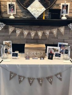 a table topped with pictures and cards under a clock on top of a fireplace mantle