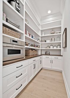 a kitchen with white cabinets and wood flooring