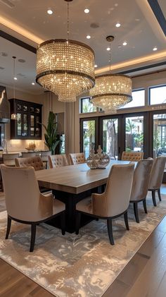 a large dining room table surrounded by chairs and chandelier with lights hanging from the ceiling