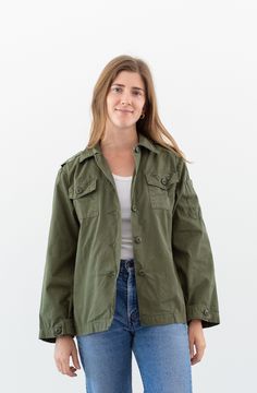 "Olive green jacket shirt with button closure and two front chest pockets, epaulettes. Maker: Military  |  Made in USA.  |  Material: Cotton Poplin Condition: Excellent.   X-SMALL: Shoulders: 16\"  |  Chest: 19\"  |  Length: 25\"  |  Sleeve: 22\" SMALL: Shoulders: 16.5\"  |  Chest: 21\"  |  Length: 25\"  |  Sleeve: 22\" Alex is 5'5\" and wears a modern small. She is wearing the X-SMALL here. SHOP http://www.rawsonstudio.etsy.com FOLLOW US + instagram | @_rawson + pinterest | rawson **No Returns. Items are eligible for store credit only. We ask that the buyer ship to provided address and a credit code is issued for one year.**" Green Button-up Outerwear With Flap Pockets, Green Collared Outerwear With Patch Pockets, Green Utility Jacket With Flap Pockets For Winter, Green Cotton Utility Jacket With Buttoned Pockets, Khaki Button-up Outerwear With Patch Pockets, Green Buttoned Pockets Outerwear For Work, Green Outerwear With Buttoned Pockets For Work, Green Workwear Tops With Flap Pockets, Green Tops With Flap Pockets For Work