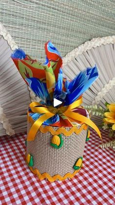 a small basket with colorful decorations on top of a red and white checkered table cloth