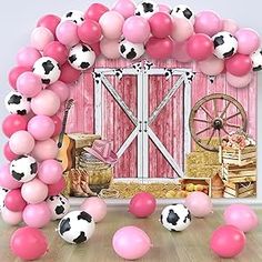 a pink and white balloon arch decorated with black and white polka dot balloons in front of a barn door