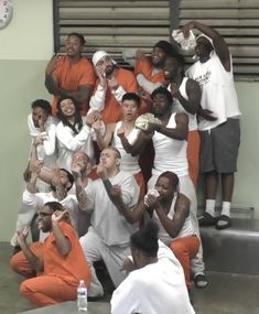 a group of people in orange and white outfits posing for a photo with each other