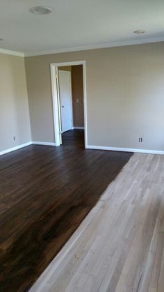 an empty living room with hard wood floors