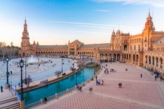 people are walking around in front of an ornate building with fountains and plazas on both sides