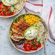 two plates filled with chicken, rice and vegetables