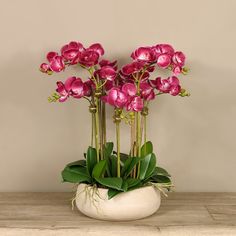 some pink flowers are in a white vase