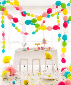 a party table with balloons and confetti