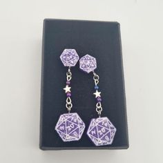 These polyhedral dice D20 earrings make the perfect geeky gift for any RPG player or boardgamer.  These earrings are cast from resin and available in any colour you would like, with a stud fastening and beaded star drop section. Full length is 5.5cm. These have hypoallergenic stainless steel studs. If you require silver please see my hooked earrings. Detailing will be either black or white depending on what works best with the colour you have chosen. If you have a preference please let me know. Fandom Style Personalized Jewelry Gift, Personalized Fandom Jewelry Gift, Silver Earrings With Diamond Markers As Gift, Geek Earrings, Geeky Jewellery, Dice Earrings, Dnd Gift, Nerd Crafts, Beaded Star