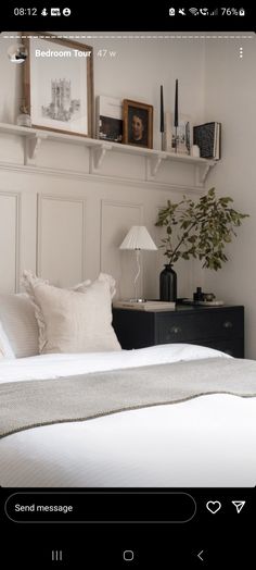 a bed room with a neatly made bed and some pictures on the wall above it