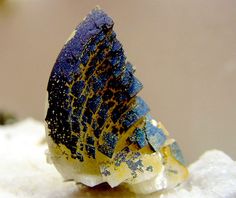 a blue and yellow piece of glass sitting on top of snow