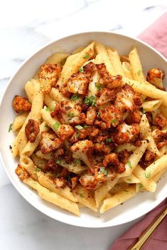 a white bowl filled with pasta and meat