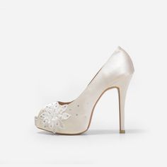 a white high heeled shoe with an embellished flower on the front and side