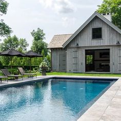 an outdoor swimming pool with lounge chairs and a shed in the backgrouf