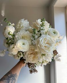 a person holding a bouquet of white flowers