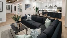 a living room filled with lots of furniture next to a kitchen and dining room table