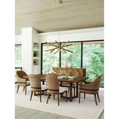 a dining room table with chairs and a chandelier in front of large windows