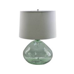 a green glass table lamp with a white shade on the base and a light grey fabric lampshade