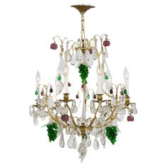 an antique chandelier with green, white and red glass beads hanging from the ceiling