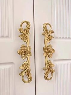 an ornate gold door handle on a white door