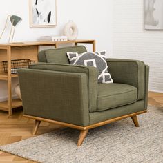 a green chair sitting on top of a wooden floor next to a white brick wall