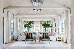 a living room filled with furniture and plants on top of it's windows sill