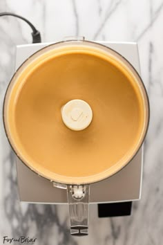 a food processor filled with liquid on top of a marble counter