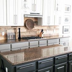 a kitchen with white cabinets and granite counter tops in front of a stove top oven