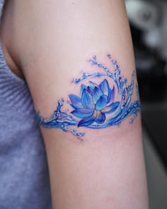 a woman's arm with a blue water lily tattoo on the left side of her right arm