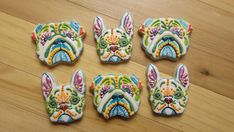 four decorated dog cookies sitting on top of a wooden table