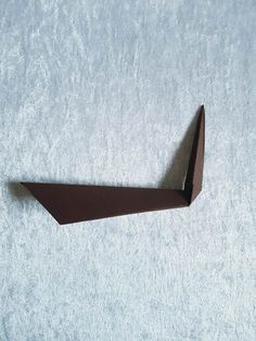 an origami boat on a white surface with no one in it's place