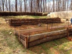 a man sitting on the ground next to some logs