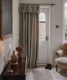 a living room filled with furniture and a window covered in curtains next to a door