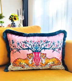 two tiger pillows sitting on top of a yellow couch