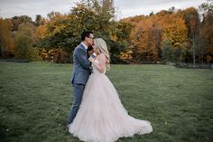 a bride and groom are standing in the grass