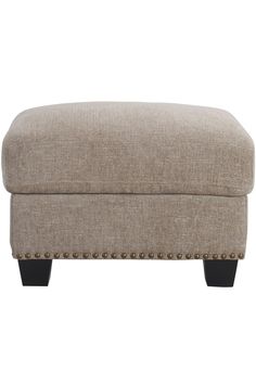 a beige ottoman with studded legs