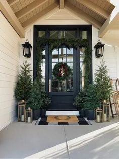 the front door is decorated with evergreens and wreaths