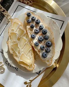 two pieces of bread with blueberries on it sitting on a plate next to a napkin