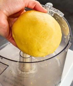 a person holding a ball of dough in a food processor