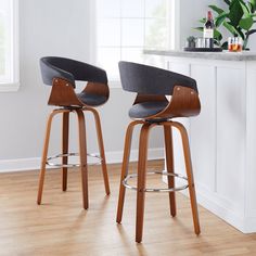 two modern bar stools with wooden arms and backrests in a white kitchen